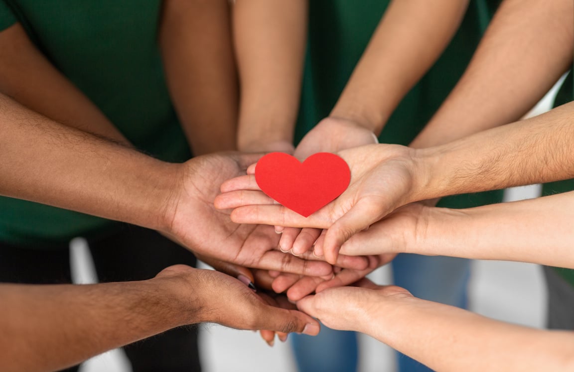 Close up of Volunteers's Hands Holding Red Heart